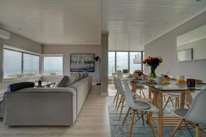 ein Wohnzimmer und ein Esszimmer mit einem Sofa und einem Tisch in der Unterkunft Ocean Blue Apartment & Studio in Monte Estoril