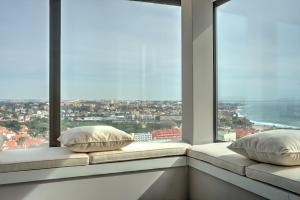 zwei Kissen auf einem Fensterbrett mit Aussicht in der Unterkunft Ocean Blue Apartment & Studio in Monte Estoril