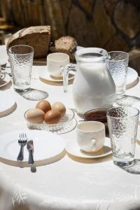 a table with eggs and plates and a pitcher of milk at Kantouni Apartments in Svoronata