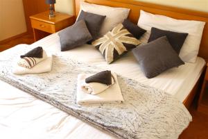 a white bed with pillows and towels on it at Villa Luka in Pag