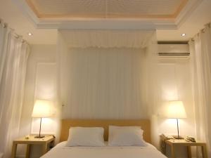 a bedroom with a bed with two lamps on two tables at São Gonçalo - Alojamento in Azeitao