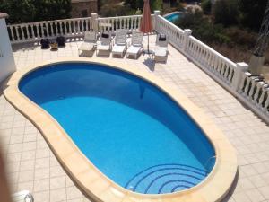 a large swimming pool with chairs at Casa Pauline in Benissa +16 photos