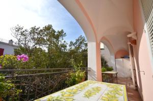 a balcony of a house with a table and flowers at CASA GADEAMUS via le botteghe 12 in Capri