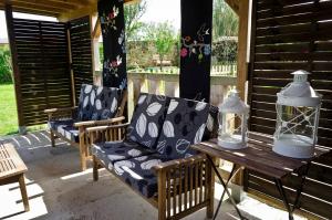 a porch with two chairs and a table with a lantern at Apartamentos Playa Galizano in Galizano