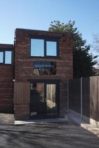un edificio de ladrillo con un cartel que lee la corte de recepcionista en Apartment 2 Broadhurst Court sleeps 6, minutes from town centre & trains, en Stockport