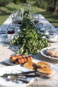 einen langen Tisch mit Teller mit Lebensmitteln drauf in der Unterkunft B&B La Fustaia in Sarzana