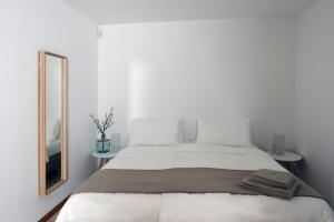 a white bedroom with a large bed with a mirror at Modern & Comfy Sea View House NG in Portorož