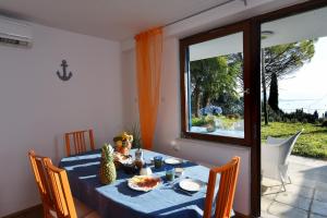 a dining room table with a blue table cloth and a window at Modern & Comfy Sea View House NG in Portorož