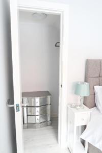 
a room with a bed, chair and a mirror at 2 The Mews, Upper Bath Street in Cheltenham
