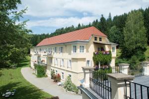 un gran edificio con flores en el balcón en Hotel Landsitz Pichlschloss en Neumarkt in Steiermark