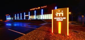 una señal frente a un edificio con luces azules en Hotel Magnus Trenčín, en Trenčín