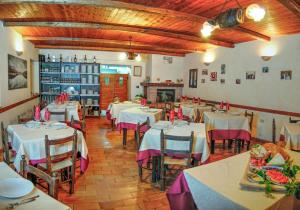un restaurante con mesas y sillas blancas y chimenea en Agriturismo La Ferrera en Varco Sabino