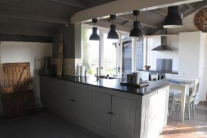 a kitchen with a black counter top and a table at Buitenuit in Boxtel