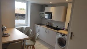 una cucina con lavatrice e tavolo di Appartement T2 proche gare et centre Bourgoin a Bourgoin