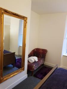 a mirror in a room with a brown leather couch at The Snug at Plover Cottage Lindley in Huddersfield