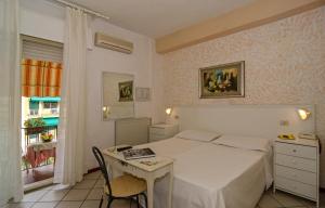 a bedroom with a bed and a table and a window at Hotel Euromar in Marina di Massa +66 photos