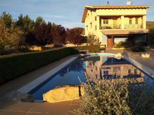 una casa con piscina delante de una casa en Physionatural B&B, en Mas de las Matas