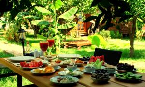 a wooden table with food and drinks on it at Baraka House in Cıralı