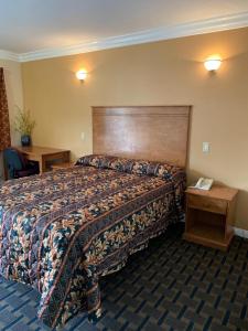 Habitación de hotel con cama y cabecero de madera en Fullerton Lodge, en Fullerton