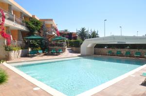 ein großes Schwimmbad vor einem Gebäude in der Unterkunft Palm Village in Villasimius