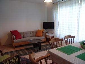 Villa Kirişhome في باتارا: غرفة معيشة مع أريكة وطاولة مع كراسي
