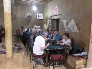 a group of people sitting at a table in a restaurant at Auberge Camping La Liberté in Merzouga