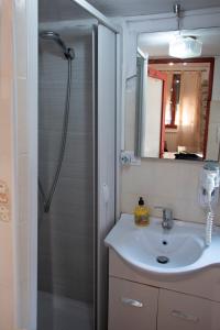 a bathroom with a sink and a shower with a mirror at Vintage Room in Vernazza