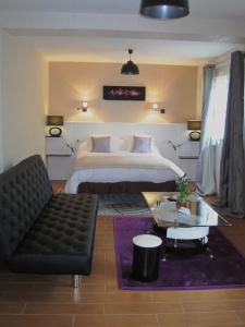 1 dormitorio con cama, sofá y mesa en Hotel Restaurant Rive Gauche, en Bessines-sur-Gartempe