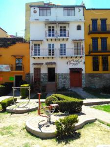 ein weißes und gelbes Gebäude mit einem Hof davor in der Unterkunft Los Pueblitos de Guanajuato Hotel in Guanajuato