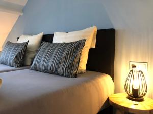 a bedroom with a bed with pillows and a lamp at Fila Stroo in Kamperland