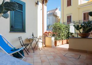 a patio with chairs and a table on a building at Nonna Anna Rooms in Palermo