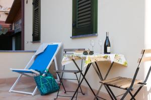 a table and chairs with a painting and a bottle of wine at Nonna Anna Rooms in Palermo