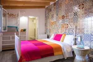 a bedroom with a colorful bed and a bathroom at Nonna Anna Rooms in Palermo