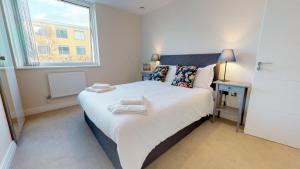 a bedroom with a large white bed with a window at NIKSA Serviced Accommodation - Welwyn Garden City Business Park in Welwyn Garden City
