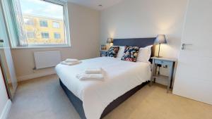 A bed or beds in a room at NIKSA Serviced Accommodation - Welwyn Garden City Business Park