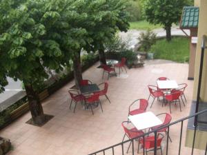 an outside patio with tables and chairs and trees at Hotel Restaurant Rive Gauche in Bessines-sur-Gartempe