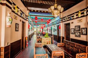 a long hallway with tables and chairs in a building at สงขลาแต่แรก แอนทีค โฮเท็ล Songkhla Tae Raek Antique Hotel in Songkhla