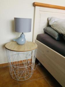 a lamp on a round table next to a bed at Kleine Harzzeit in Hahnenklee-Bockswiese