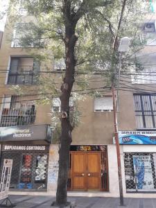 un árbol en una acera frente a un edificio en Departamento Céntrico Ciudad de Mendoza en Mendoza