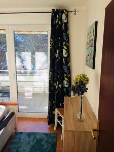 a living room with a window and a vase of flowers at Kleine Harzzeit in Hahnenklee-Bockswiese