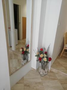 a mirror with a bouquet of flowers in a hallway at Studio Rose in Pula