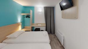 En eller flere senge i et værelse på Hôtel du stade ex Kyriad Direct Lille Est Stade Pierre Mauroy