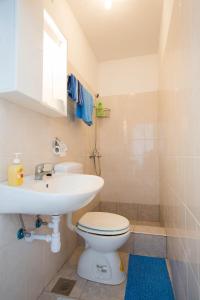 a bathroom with a white toilet and a sink at Holiday Home Ratac Sunshine Beach in Slano