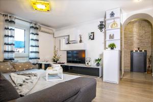 a living room with a couch and a tv at Carli in Rabac
