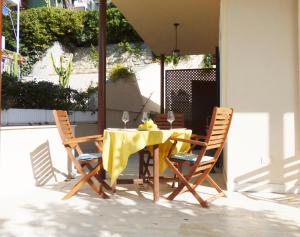 une table avec un chiffon de table jaune et deux chaises dans l'établissement Della Rose, à Ospedaletti