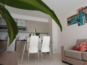 a living room with a table and white chairs at Boulogne Design Suites in Mendoza +51 photos