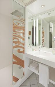 La salle de bains est pourvue d'un lavabo et d'un miroir. dans l'établissement Mercure Chambéry Centre, à Chambéry