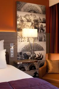 a hotel room with a bed and a lamp and a couch at Mercure Chambéry Centre in Chambéry