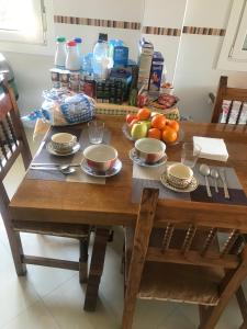 drewniany stół z talerzami i miskami owoców w obiekcie Alojamiento MARTEL w mieście Majadahonda