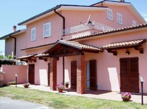 Una casa con pintura rosa. en Villa Etruria Guest House, en Pitigliano